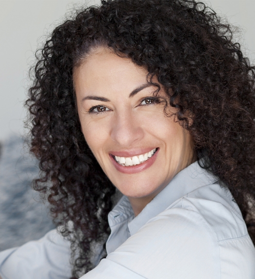 Smiling woman with dark, curly hair