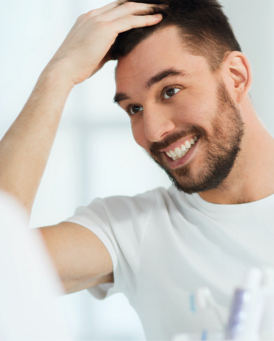 Smiling man touching his hair